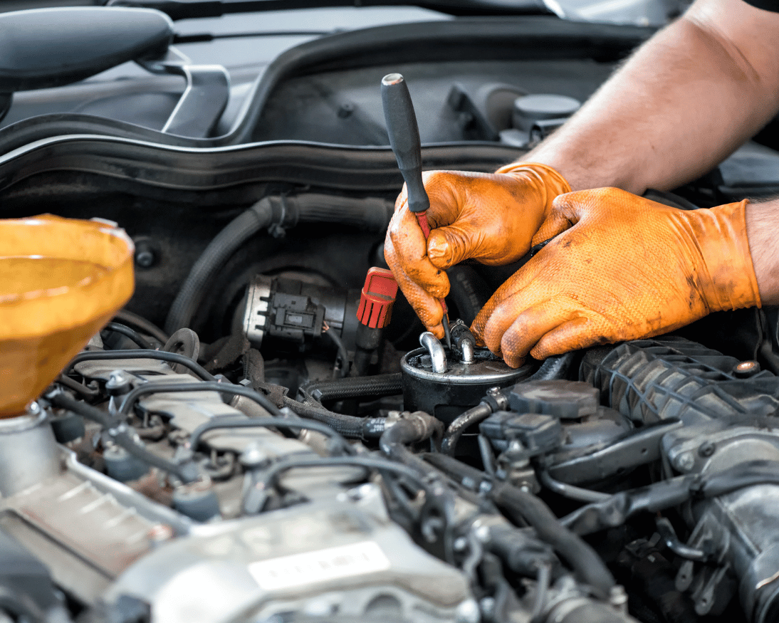 Mobile mechanic working inside a vehicle engine bay